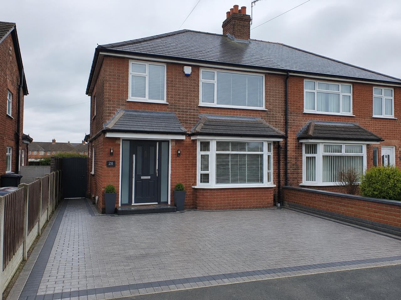 Block paved driveway in front of a UK semi-detached house with a tiled roof